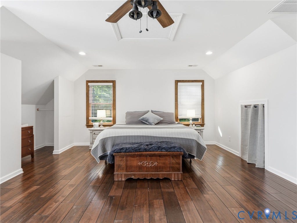 16233 Pleasant Mill Road, Montpelier, VA 23192 Spacious room featuring wood-finish flooring, vaulted ceilings, two windows with wooden trim, and a ceiling fan with light fixture