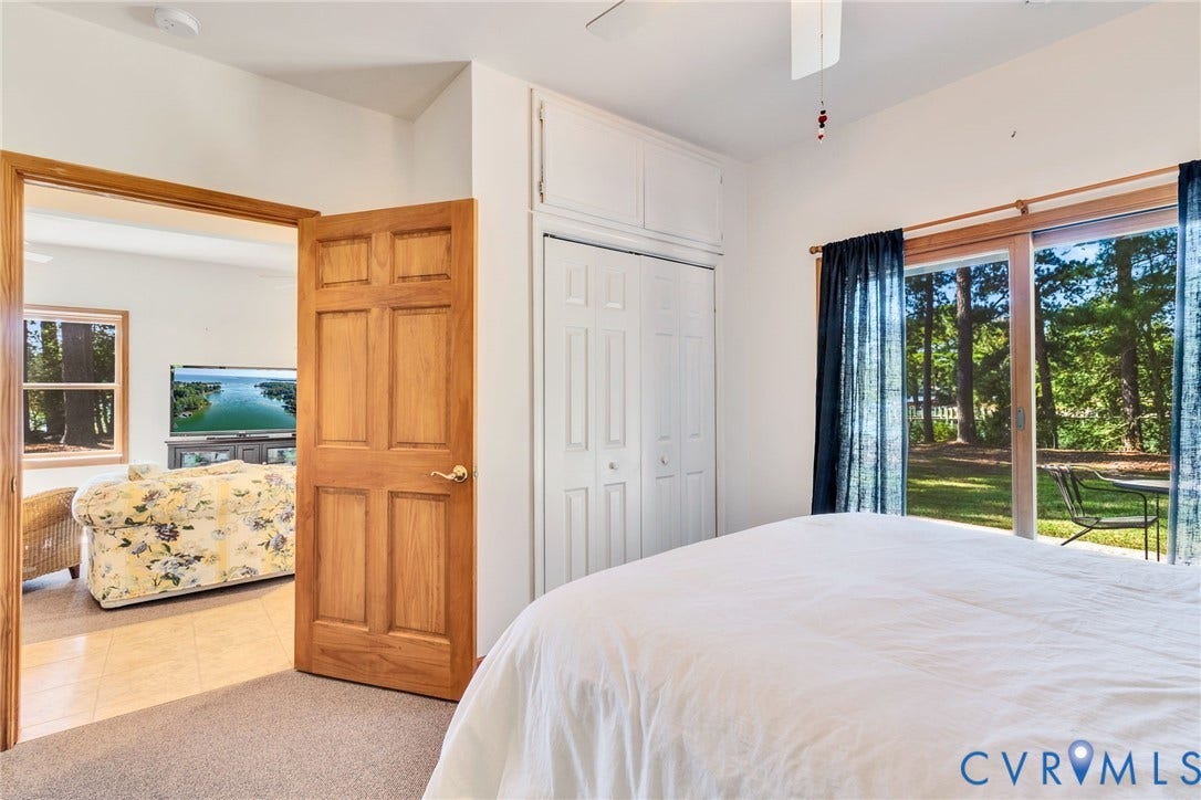 Wood-paneled door, built-in storage cabinetry, sliding glass door, private patio access, and landscaped outdoor area in Guest Cottage