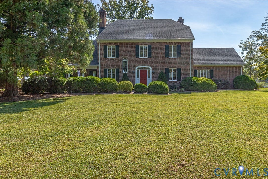 Traditional brick exterior with a prominent red entry door