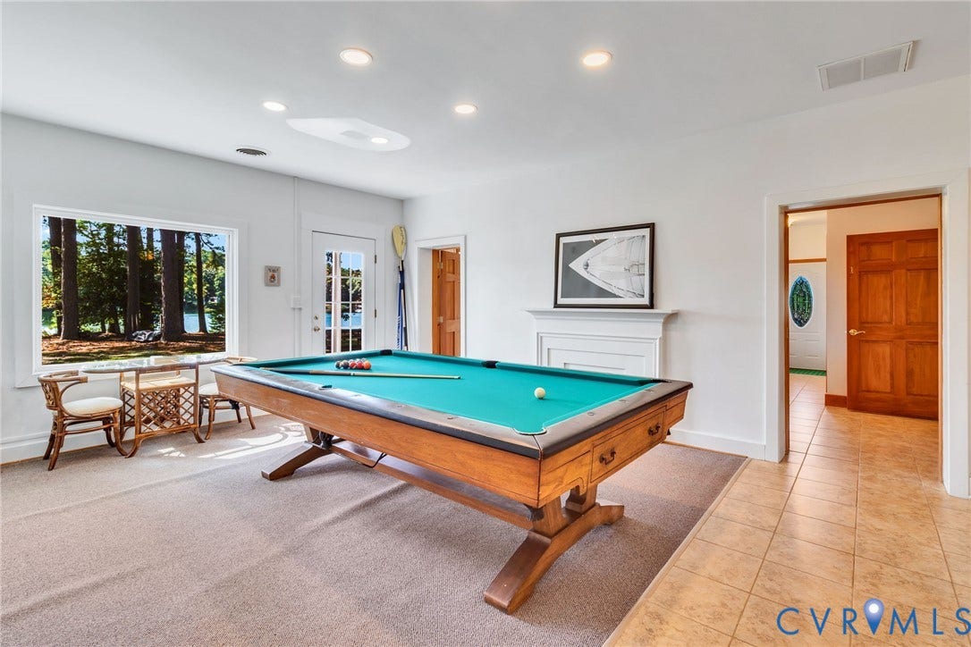 Recessed lighting, light-colored walls, and neutral carpet create a bright interior