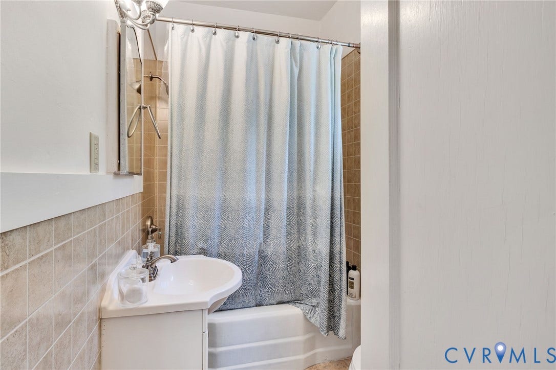 White corner vanity with an integrated sink and chrome faucet-guest cottage