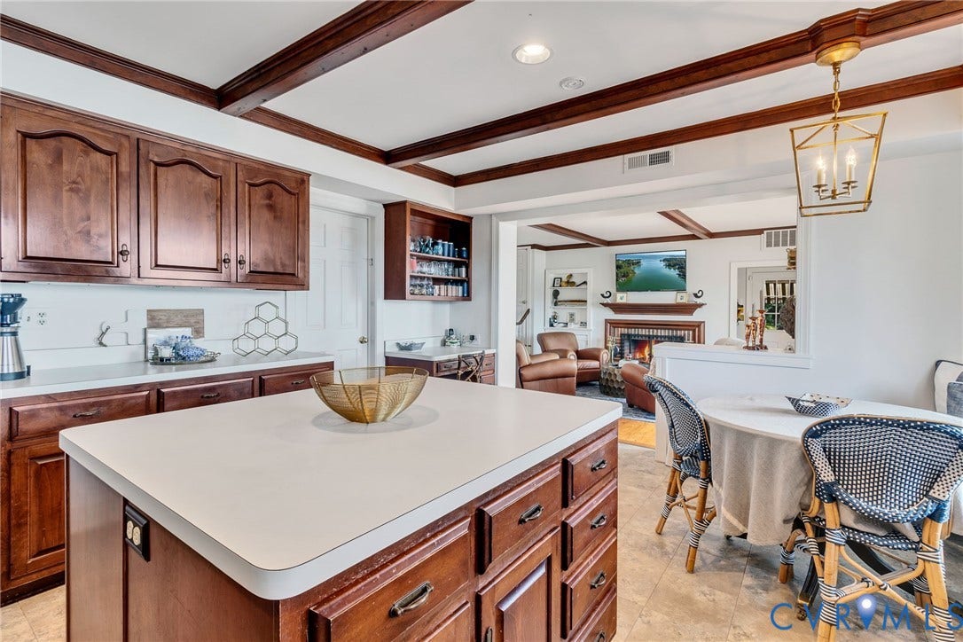Kitchen featuring wood cabinetry, a center island and water view eat in area