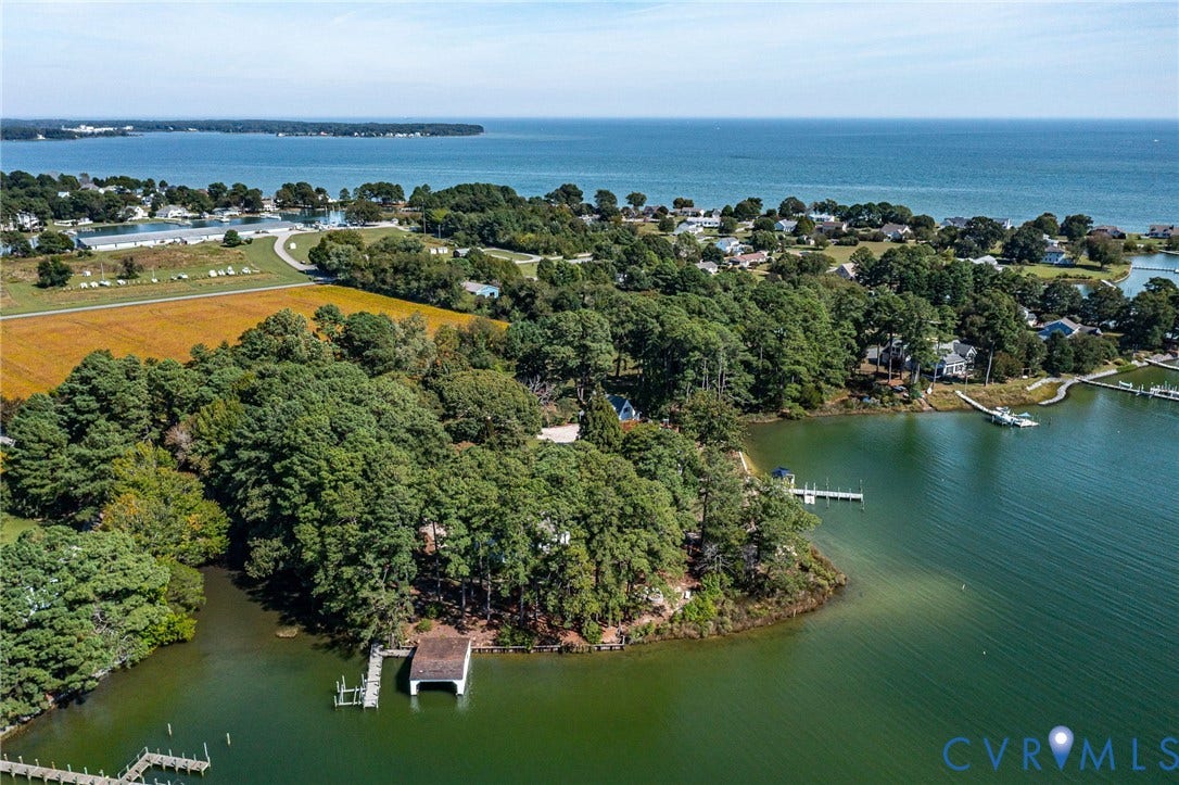 Waterfront property featuring extensive tree cover, a private boat house, and direct water access to Chesapeake Bay