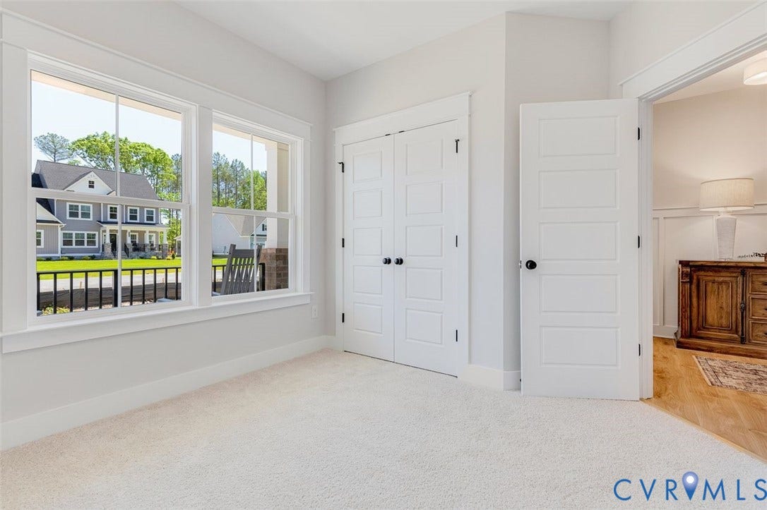 Plush carpeting, paneled interior doors, and bright windows with white trim