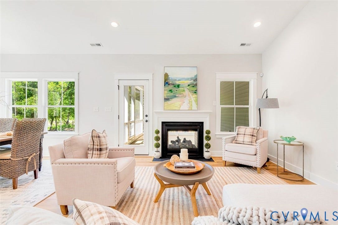 Living space featuring a fireplace with a white mantel, recessed lighting, and wood-finish flooring