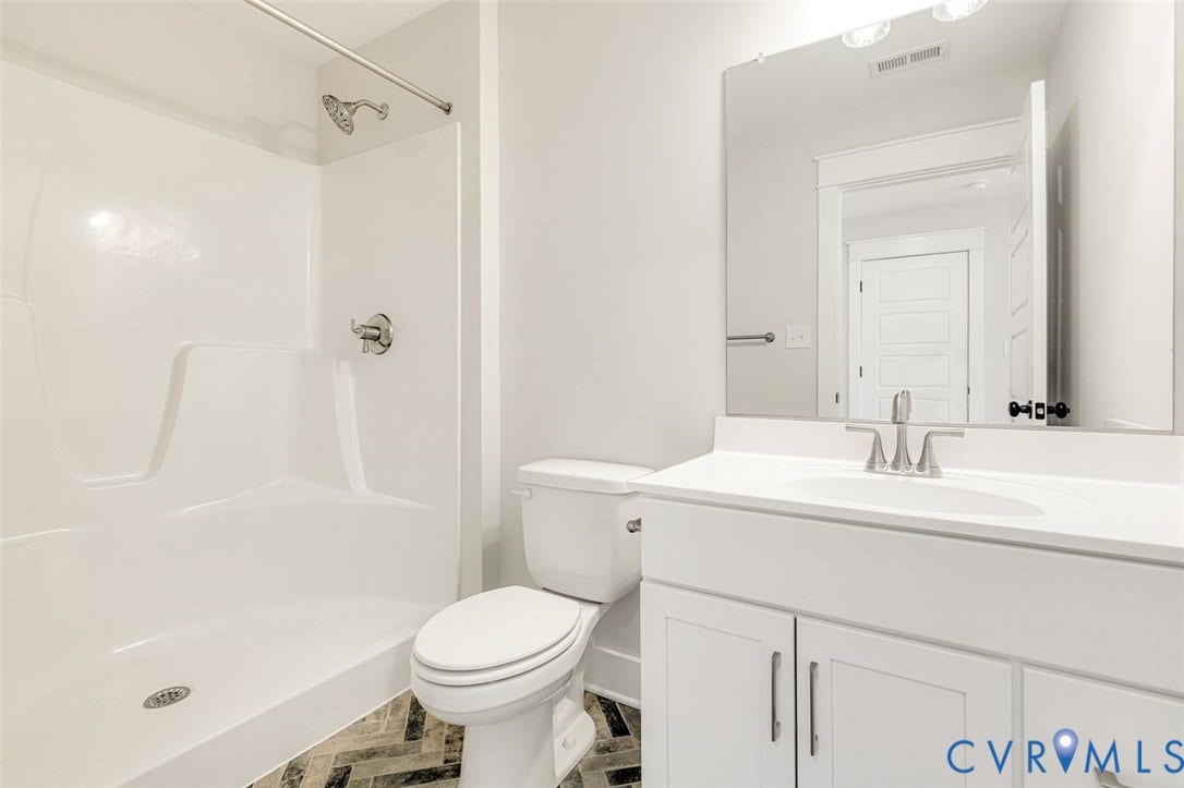 White single-piece shower surround with chrome fixtures