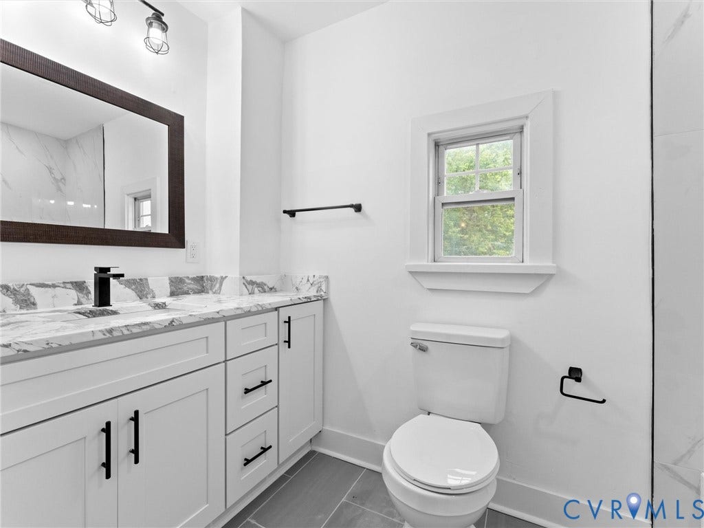 Dual sink vanity with stone-finish countertop and contemporary black fixtures