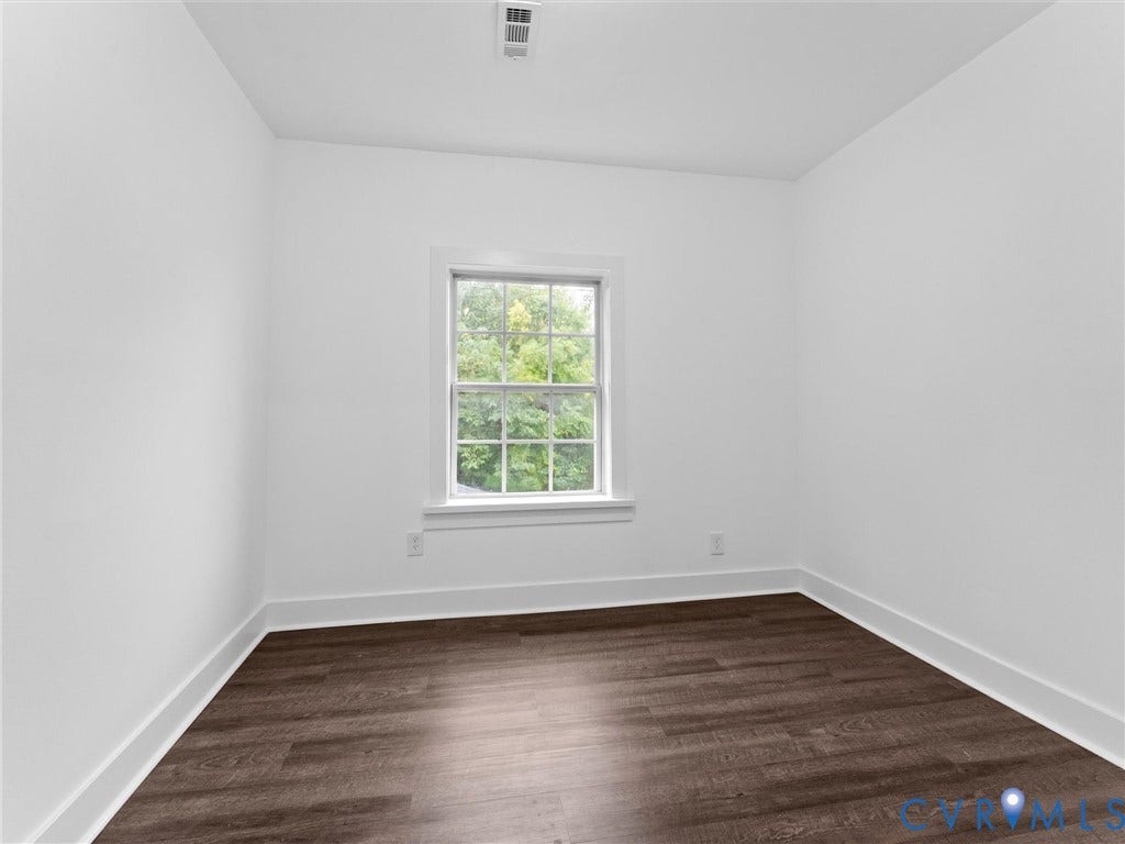 White walls, wood-finish flooring, and a window with white trim