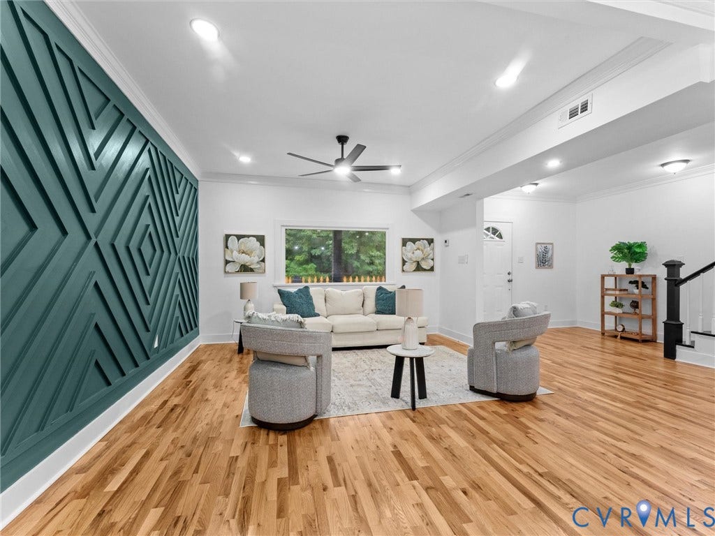 Hardwood flooring throughout, recessed lighting, ceiling fan, decorative wall paneling, and a prominent window