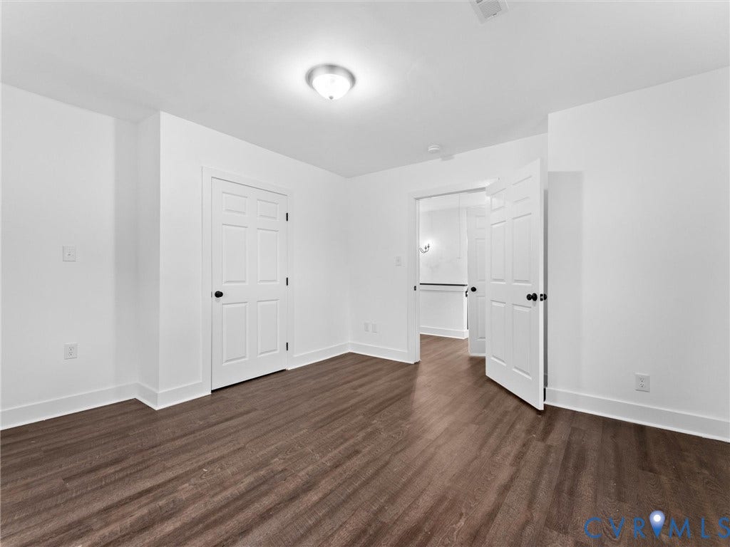 Wood-finish flooring, white walls, white trim, recessed lighting, and panel doors