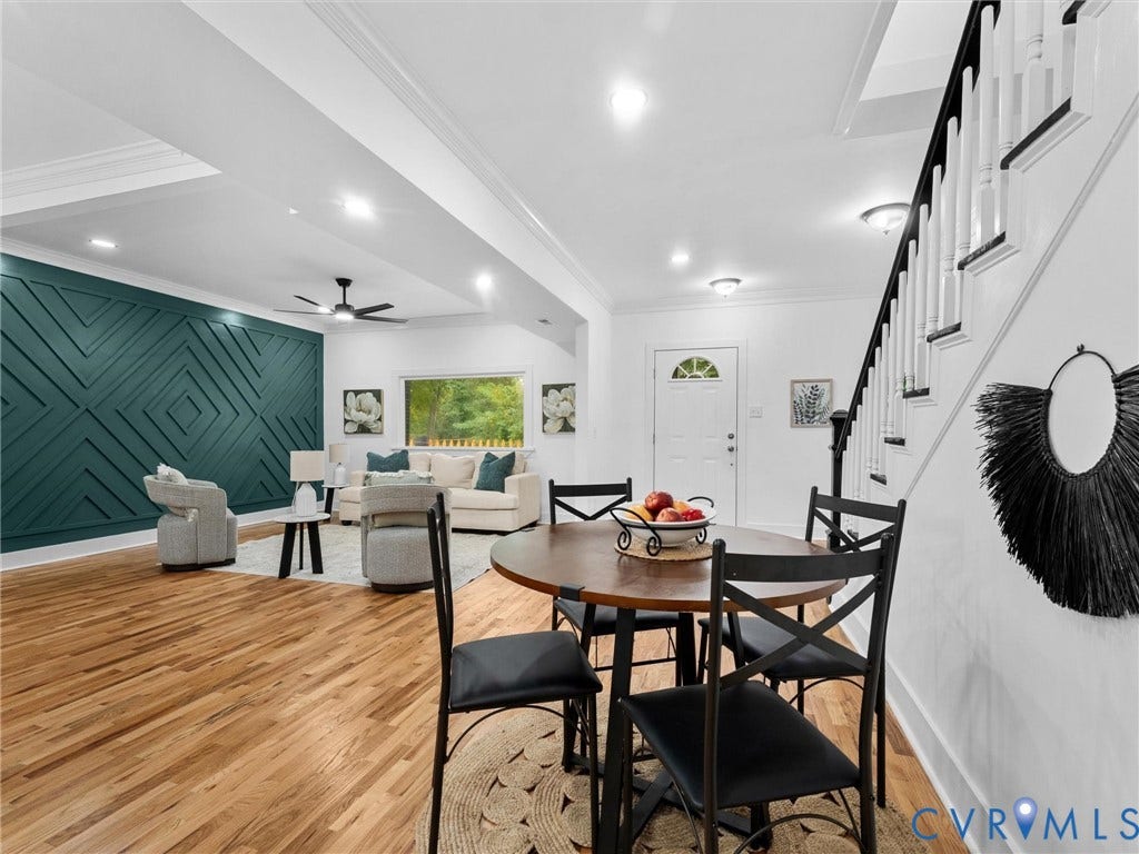 Hardwood flooring throughout, recessed lighting, and a detailed accent wall