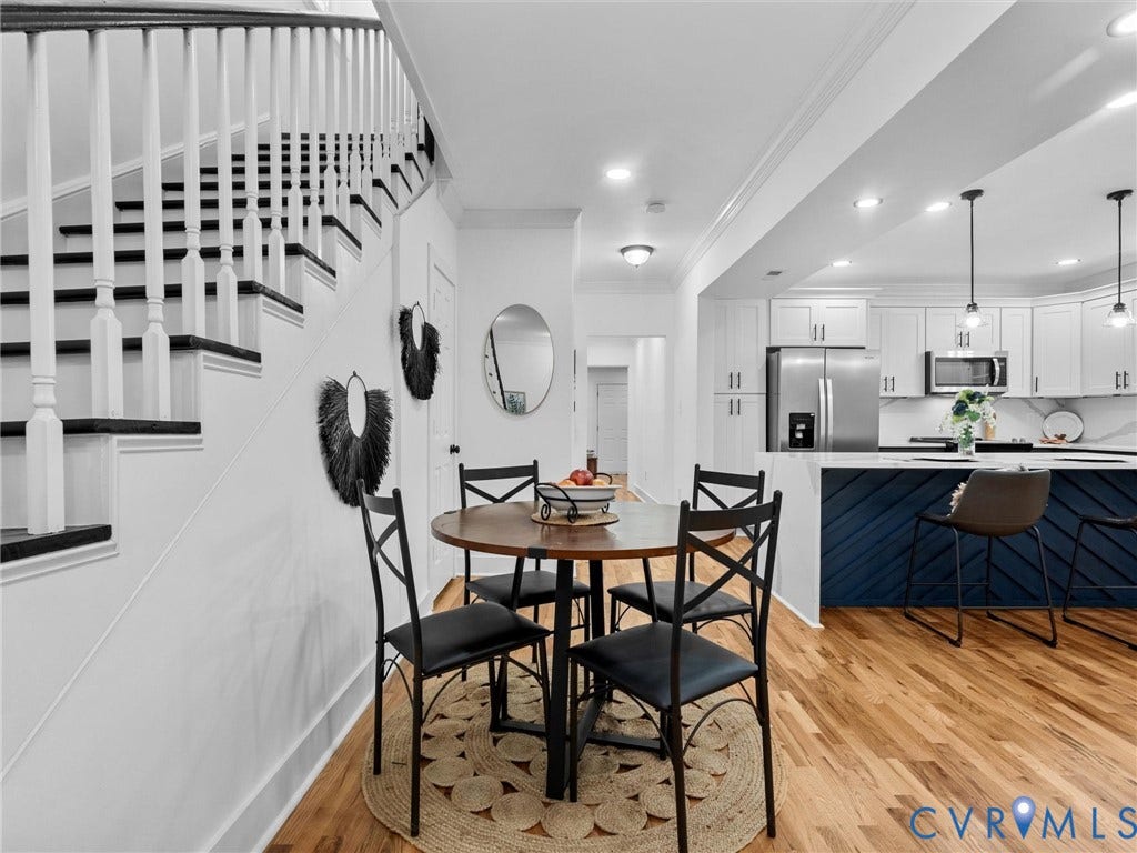 Hardwood flooring, open-concept design, recessed lighting, white cabinetry, and stainless steel appliances