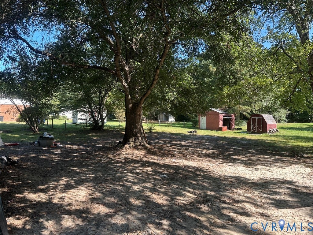 5539 Qualla Road, Chesterfield, VA 23832 Expansive yard with mature trees providing ample shade, featuring two detached storage sheds and a partially fenced perimeter