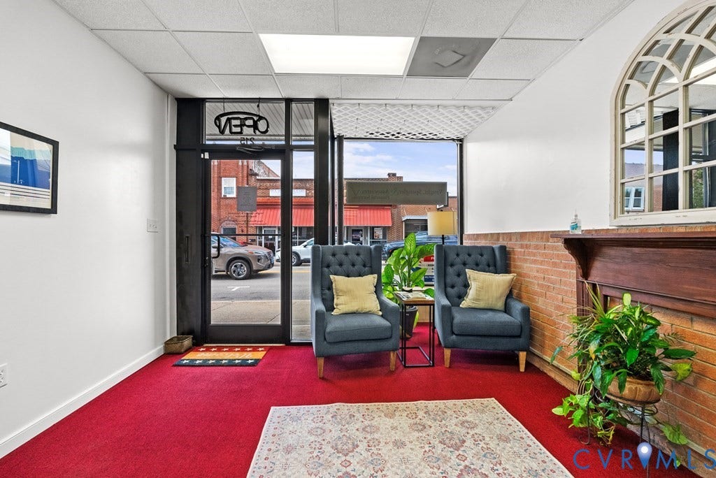 Red carpeting, a partial brick wall, and a wood-finish mantelpiece