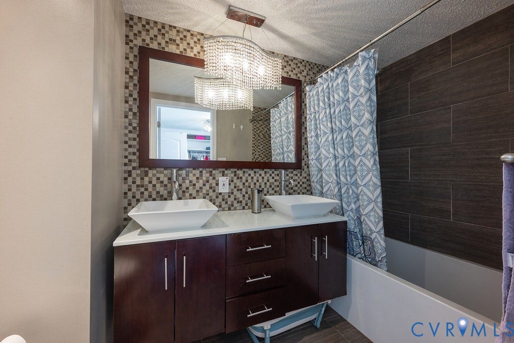Walk-in closet featuring extensive built-in shelving, hanging rods, an integrated mirror, and a window for natural light