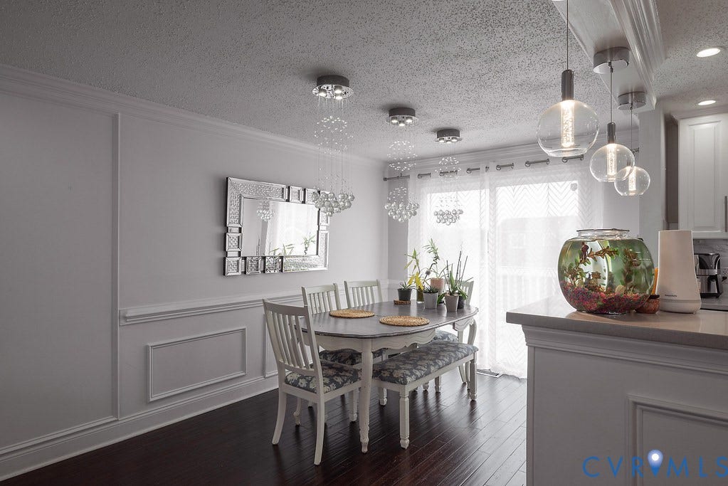 Dark wood-finish flooring complements the white wall paneling