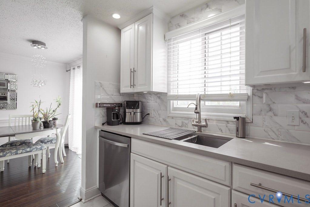 Recessed lighting, contemporary pendant lights, and a built-in breakfast bar define this open living space