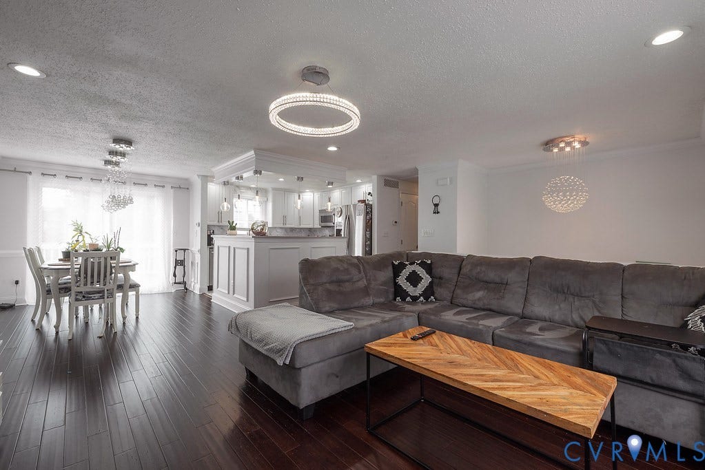 Rich wood-finish flooring, recessed lighting, and a modern circular ceiling fixture