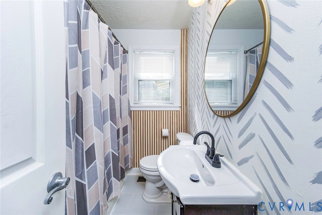 Wall-mounted vanity with a single-basin sink and a matte black faucet