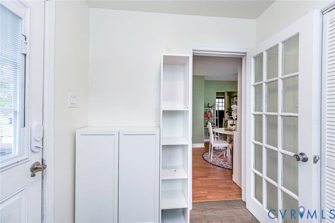 Built-in white cabinetry and shelving, adjacent to a French pane glass door