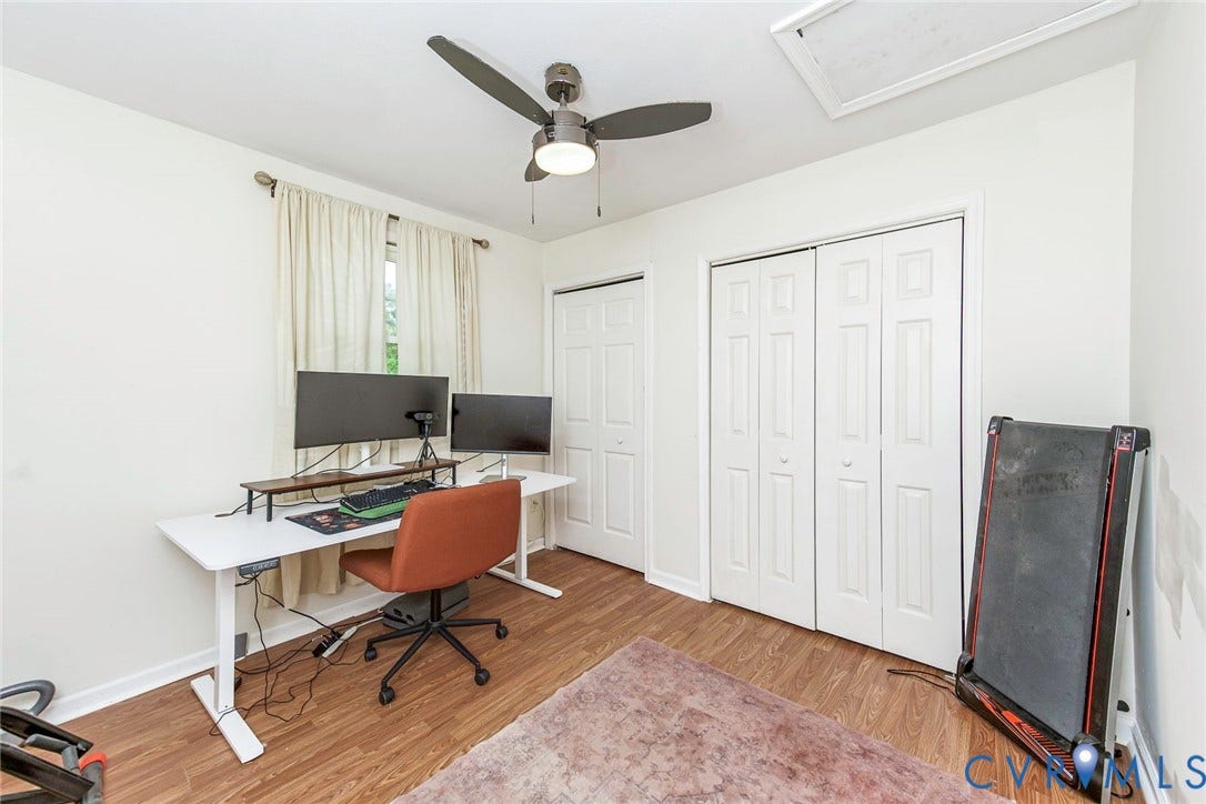 Wood-finish flooring, two bi-fold closets, and a window with natural light