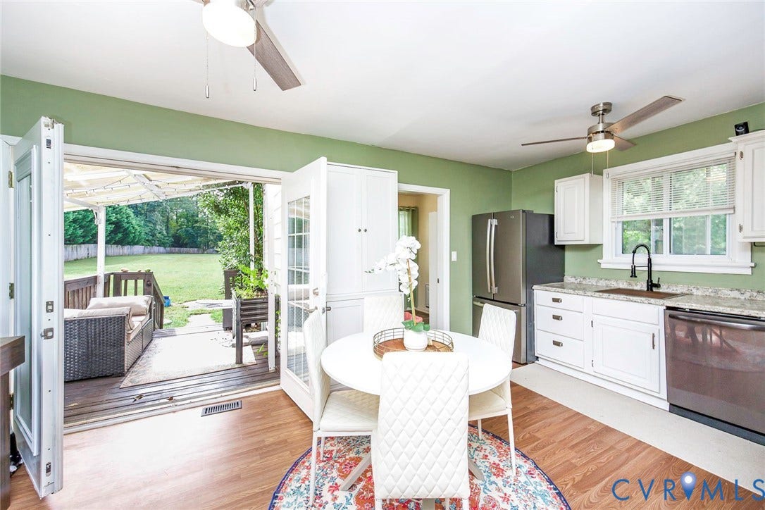 Kitchen featuring white cabinetry, stainless steel appliances, and wood-finish flooring
