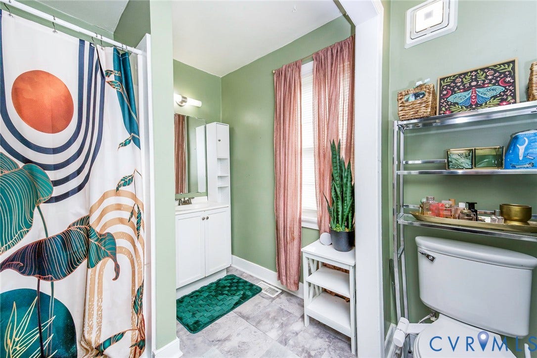 Bathroom featuring a white vanity with built-in storage, a wall-mounted mirror, and tile flooring