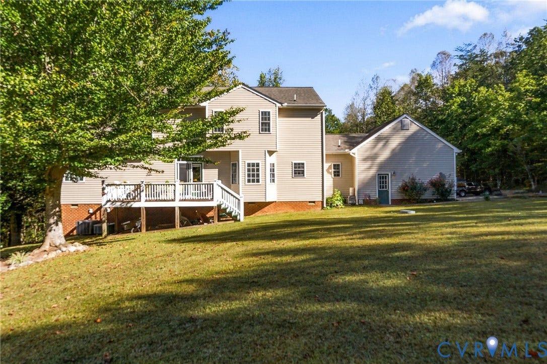 3647 Cedar Plains Road, Sandy Hook, Sandy Hook, VA 23153 Expansive backyard featuring a large tree, a raised deck with white railings, and mature trees in the background