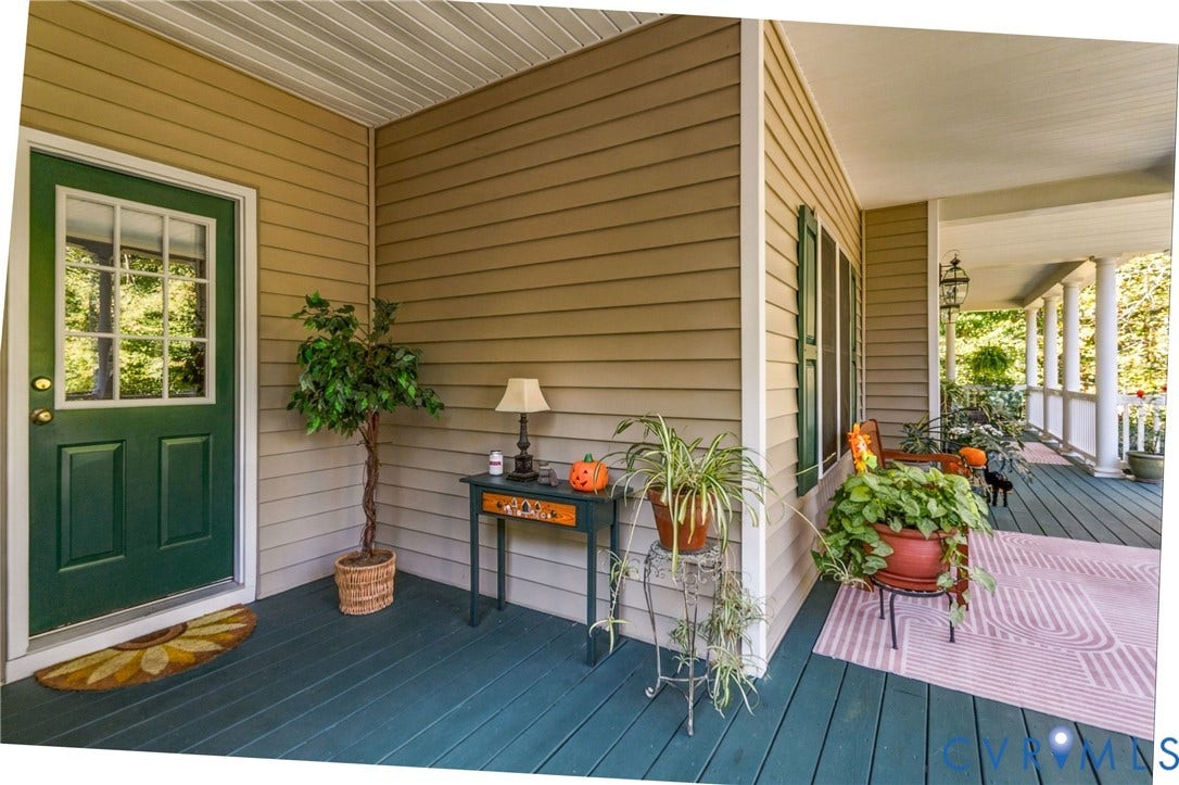 3647 Cedar Plains Road, Sandy Hook, Sandy Hook, VA 23153 Covered porch with wood-finish flooring, paneled siding, and a paneled entry door with glass inserts