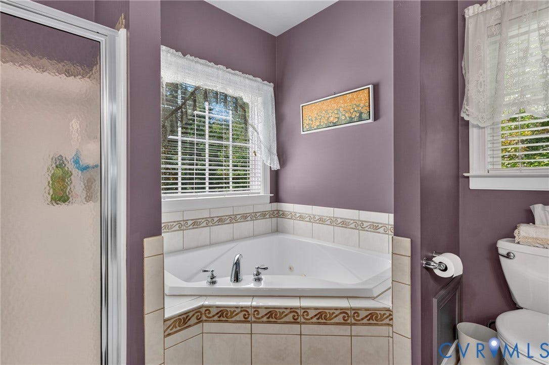 3647 Cedar Plains Road, Sandy Hook, Sandy Hook, VA 23153 Corner jetted tub with tile surround, frosted glass shower enclosure, and a window with blinds