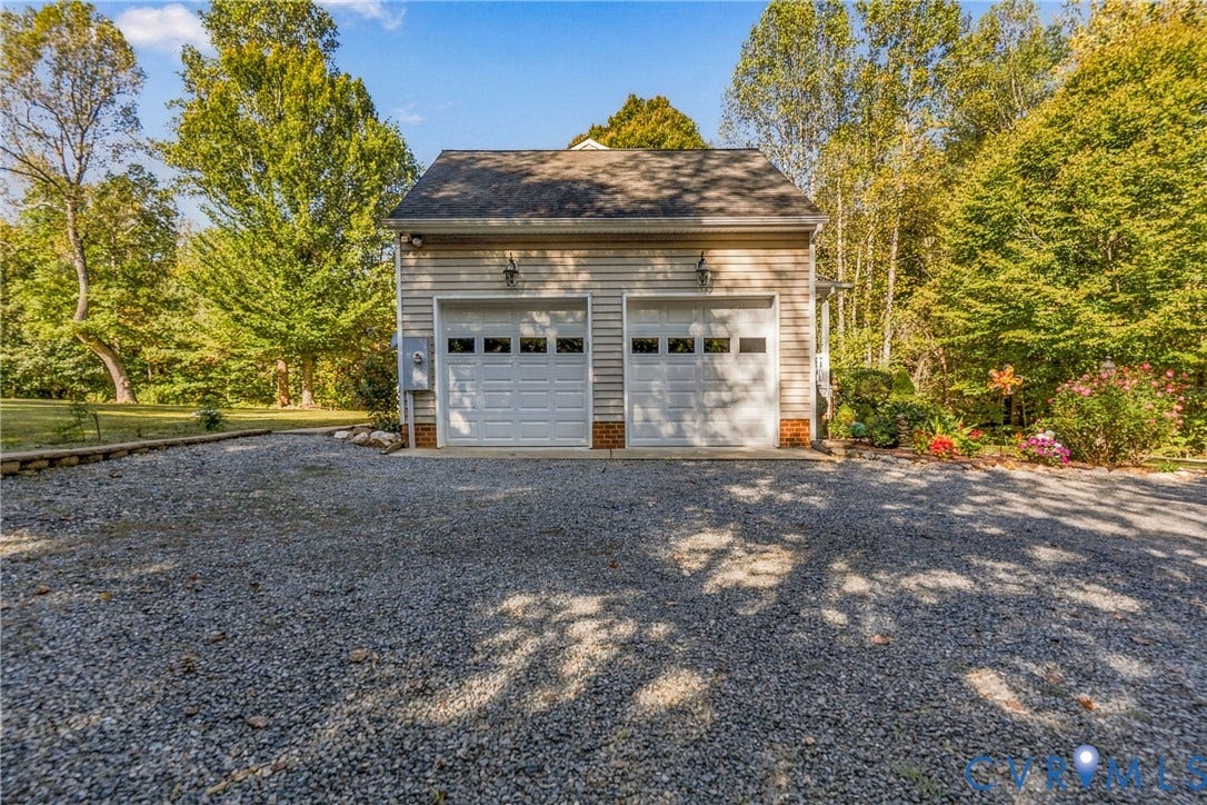 3647 Cedar Plains Road, Sandy Hook, Sandy Hook, VA 23153 Two-car detached garage with horizontal siding, dual overhead doors, and exterior lighting fixtures