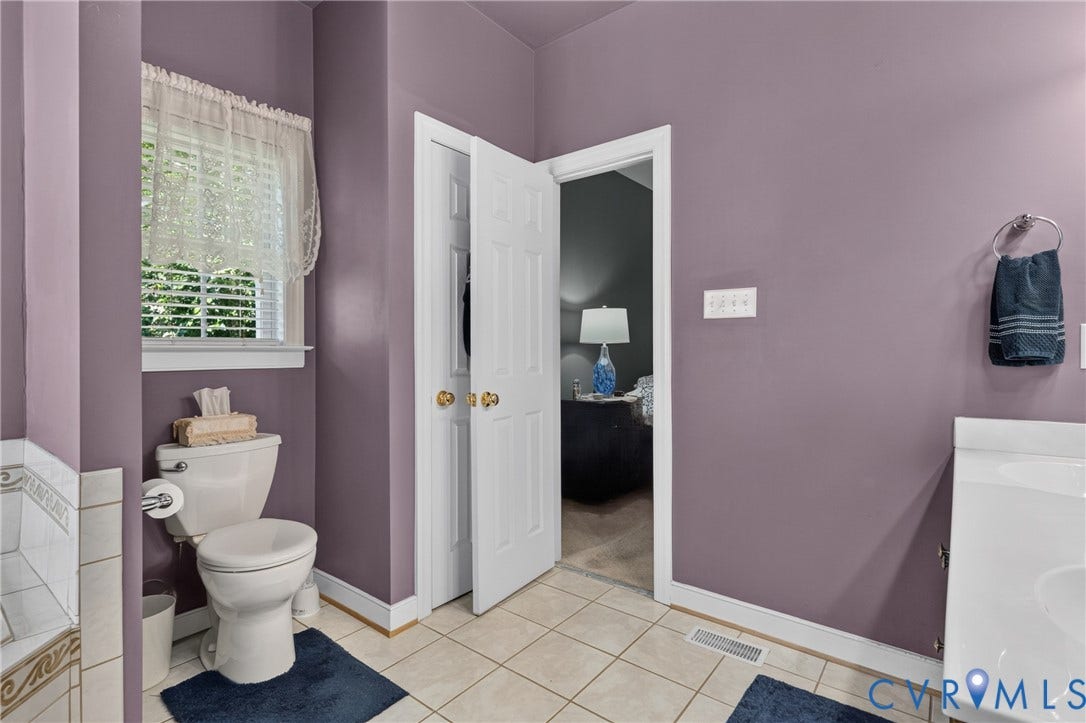 3647 Cedar Plains Road, Sandy Hook, Sandy Hook, VA 23153 Tile flooring, white toilet, window with blinds, white vanity with integrated sink, and white paneled doors