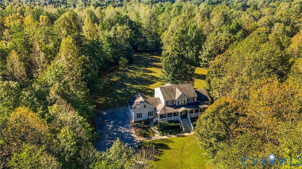 3647 Cedar Plains Road, Sandy Hook, Sandy Hook, VA 23153 Expansive property surrounded by mature trees, featuring a multi-story residence with a wrap-around porch, a paved driveway, and a verdant lawn area