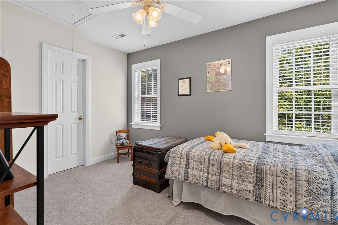 3647 Cedar Plains Road, Sandy Hook, Sandy Hook, VA 23153 Carpeted room featuring a ceiling fan with integrated lighting, two windows with blinds, and a paneled door