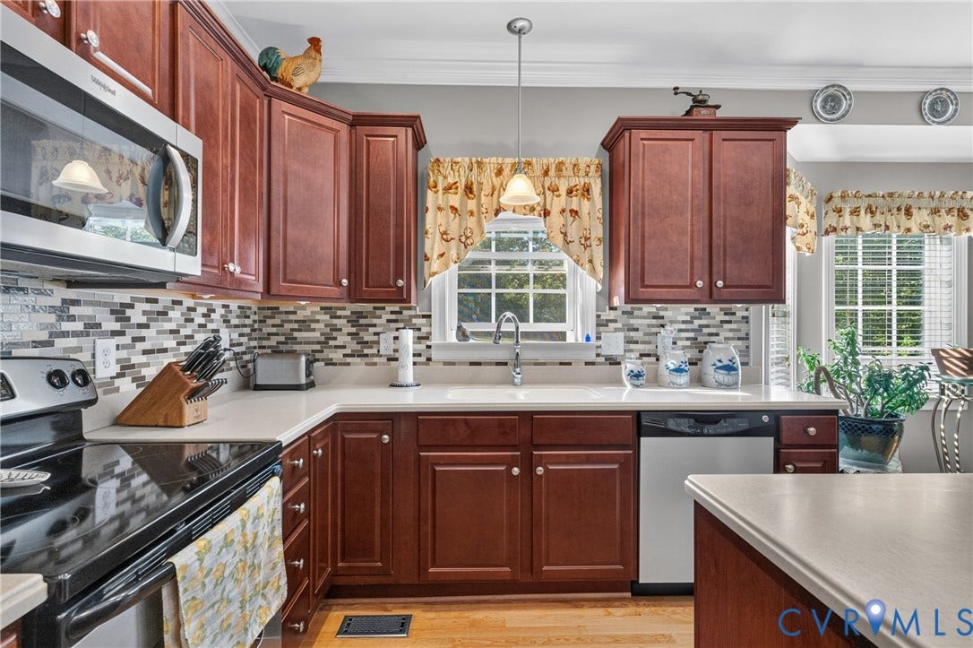 3647 Cedar Plains Road, Sandy Hook, Sandy Hook, VA 23153 Kitchen featuring wood cabinetry, light-toned countertops, a mosaic tile backsplash, and stainless steel appliances