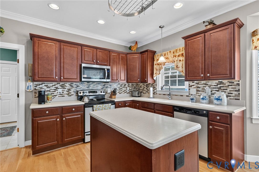 3647 Cedar Plains Road, Sandy Hook, Sandy Hook, VA 23153 Full kitchen featuring wood-finish cabinetry, stainless steel appliances, a center island with a white countertop, and a tiled backsplash