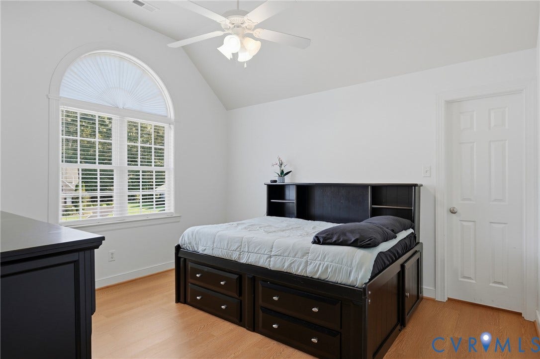 11813 Longfellow Drive, Bayhill Pointe, Midlothian, VA 23112 Vaulted ceiling featuring a central ceiling fan with integrated lighting, a large arched window with muntin detailing, and light-toned wood-finish flooring