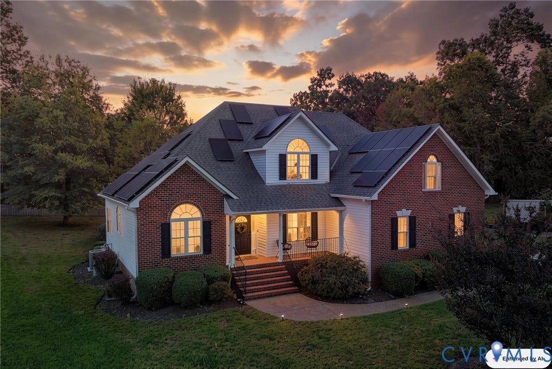 11813 Longfellow Drive, Bayhill Pointe, Midlothian, VA 23112 Two-story brick and siding exterior featuring roof-mounted solar panels, arched windows, an elevated front porch with railing, and a concrete walkway