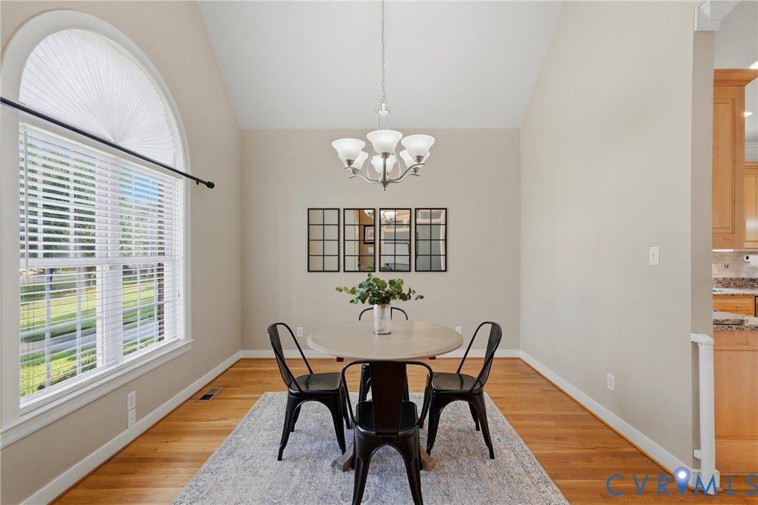 11813 Longfellow Drive, Bayhill Pointe, Midlothian, VA 23112 Vaulted ceilings, expansive arched window with grid detailing, wood-finish flooring, and a multi-light chandelier