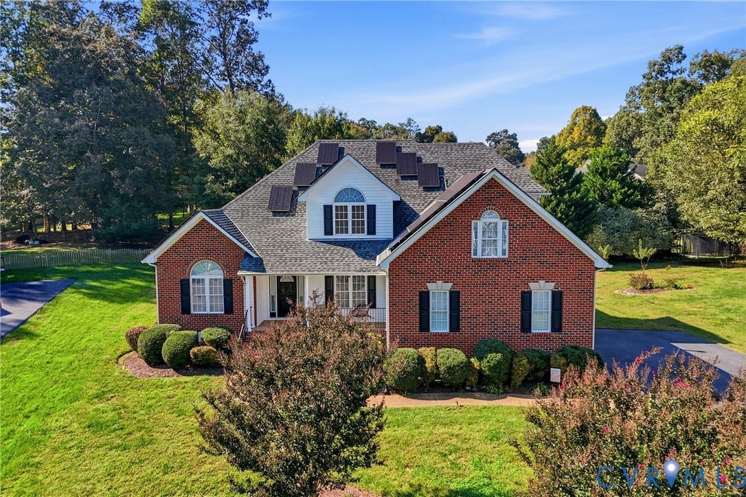 11813 Longfellow Drive, Bayhill Pointe, Midlothian, VA 23112 Traditional brick exterior featuring a multi-gabled roofline, solar panel installation, arched window accents, and an expansive lawn