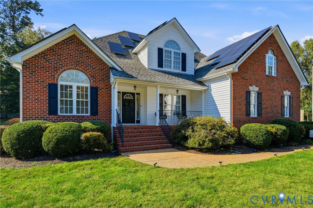 11813 Longfellow Drive, Bayhill Pointe, Midlothian, VA 23112 Multi-gabled brick and siding exterior featuring solar panel arrays, arched windows with shutters, and a front entry with brick steps and metal railings
