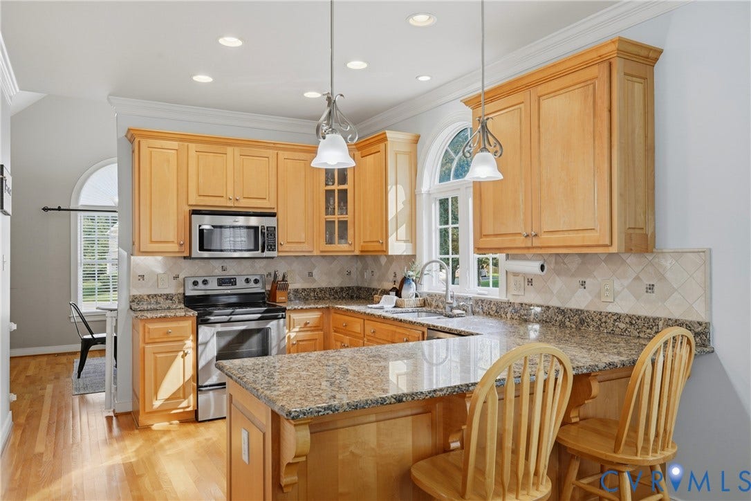 11813 Longfellow Drive, Bayhill Pointe, Midlothian, VA 23112 Kitchen featuring wood cabinetry, stone countertops, a tile backsplash, stainless steel appliances, and arched windows