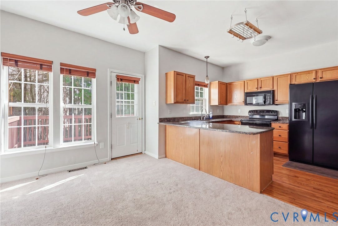 2803 Queensland Drive, #2803, Pemberton Oaks, Glen Allen, VA 23294 Kitchen featuring light wood cabinetry, stone-finish countertops, black appliances, a ceiling fan, and carpeted flooring