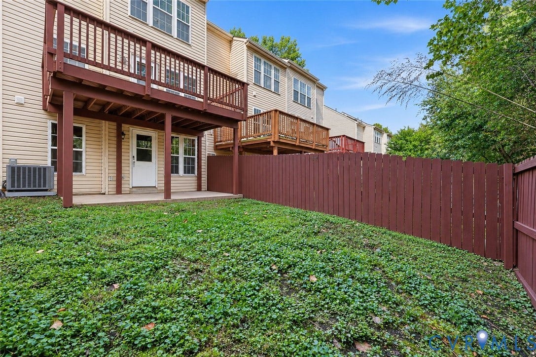 2803 Queensland Drive, #2803, Pemberton Oaks, Glen Allen, VA 23294 Exterior rear of property featuring a raised wooden deck, ground-level concrete patio, fenced yard, and vinyl siding