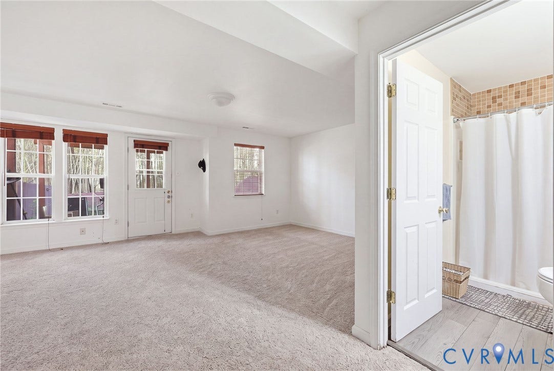 2803 Queensland Drive, #2803, Pemberton Oaks, Glen Allen, VA 23294 Open floor plan featuring carpeting, multiple windows with grid detailing, a glass-paneled exterior door, and a bathroom with tile flooring and tiled shower enclosure