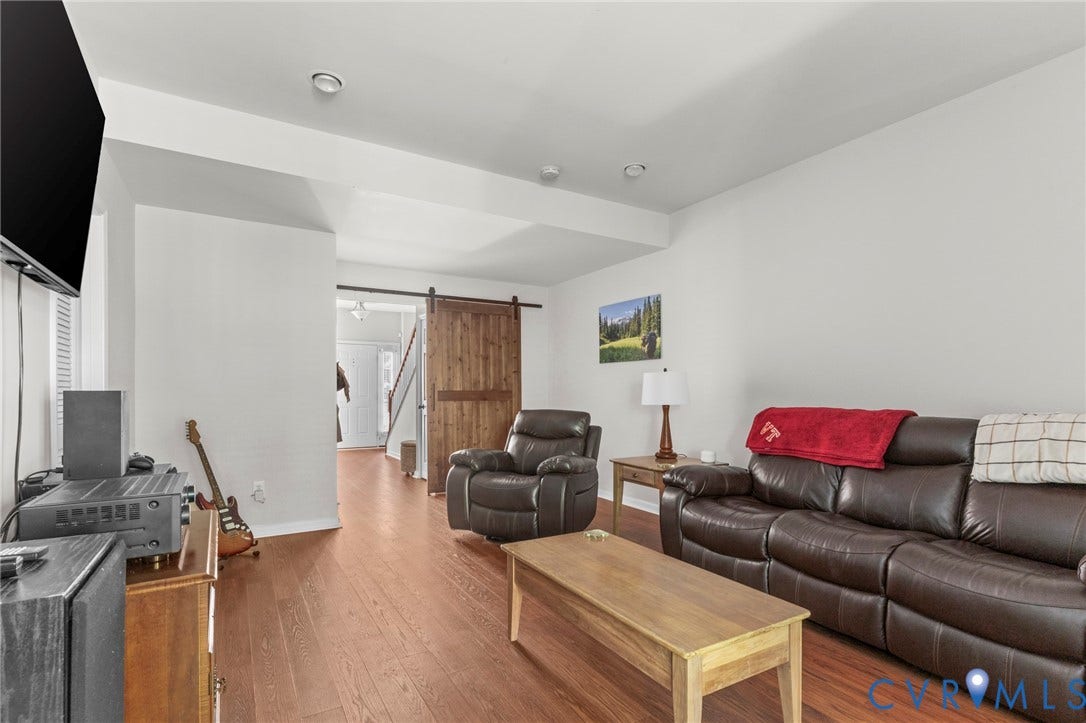 Hardwood-finish flooring, recessed lighting, and a barn door entry
