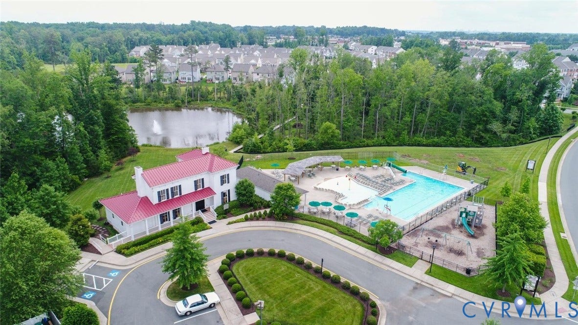 8061 Belton Circle, Hanover, VA 23116 Community building with a red metal roof, surrounded by a swimming pool, children's play area, and a pond with a fountain