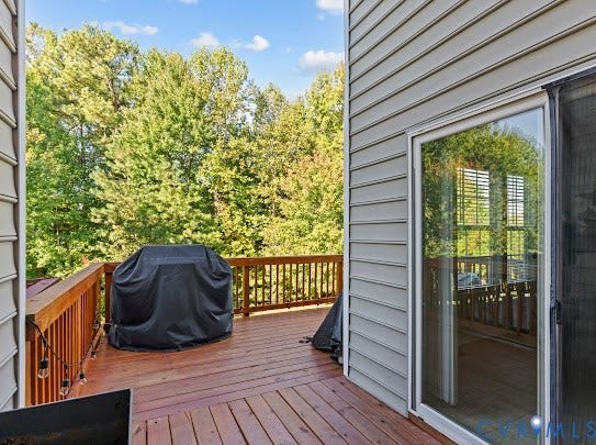 Expansive wood deck with wood railing, siding exterior, and sliding glass door access
