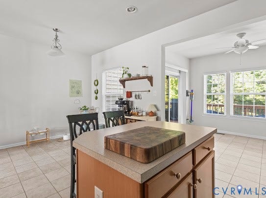 Kitchen island with light-toned countertop and wood cabinetry