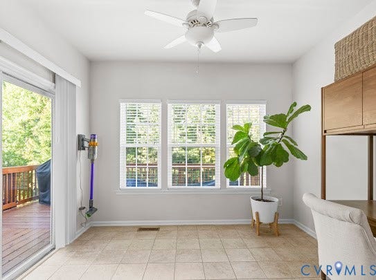 Tile flooring, multiple windows with blinds, built-in cabinetry, sliding glass door, and a ceiling fan